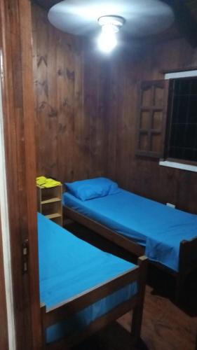 Puerto BossettiにあるCabañas Aliwenのベッド2台とテーブルが備わる客室です。