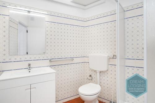 a bathroom with a toilet and a sink and a mirror at Artens 407 Dream Lodging in Albufeira