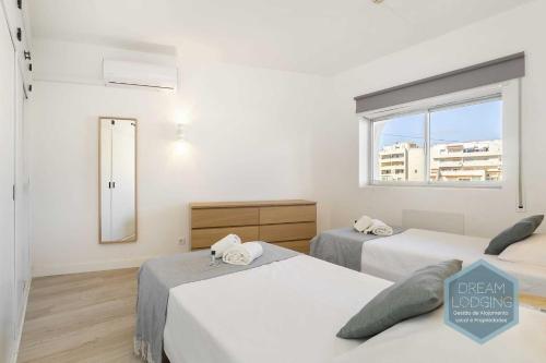 a bedroom with two beds and a window at Artens 407 Dream Lodging in Albufeira