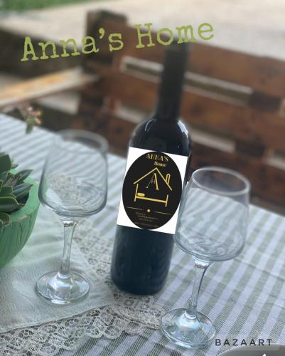 a bottle of wine next to two glasses on a table at Anna'S Home in Kutaisi