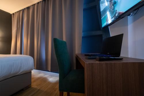 um quarto de hotel com uma secretária com um computador portátil em MA Airport Hotel em Hoofddorp