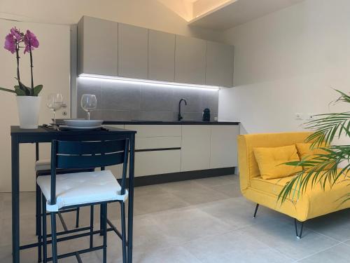 una cucina con sedia gialla, tavolo e divano di Green Home - Bellagio Apt a Como