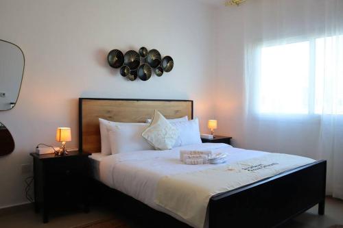 een slaapkamer met een groot bed met 2 verlichting bij Divine 1BR Apartment in Al Reef. in Yas Island