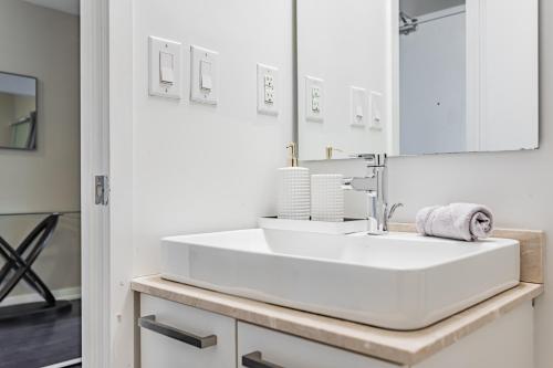 a white bathroom with two sinks and a mirror at Downtown Apartments 10 in Toronto