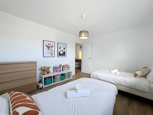 ein weißes Zimmer mit 2 Betten und einem Sofa in der Unterkunft Liberty YourHostHelper in Esquay-sur-Seulles