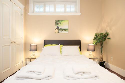 Luxurious 8-Bedroom Villa in Central Vancouver في فانكوفر: غرفة نوم بسرير ابيض كبير ومصباحين