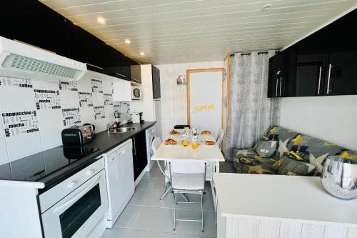 une petite cuisine avec une table et un canapé dans l'établissement Los Amigos - Studio confort proche de la plage, au Grau-du-Roi