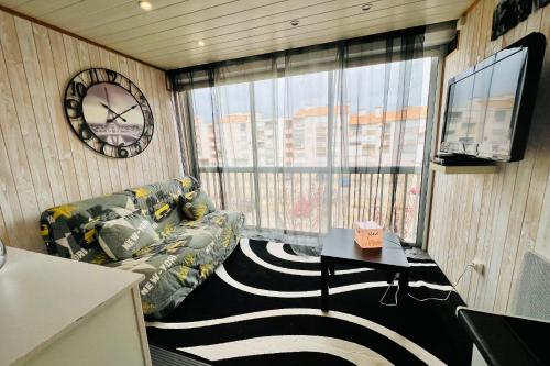 - un salon avec un canapé et un réveil dans l'établissement Los Amigos - Studio confort proche de la plage, au Grau-du-Roi