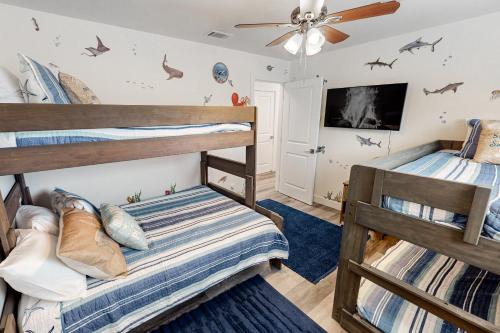 two bunk beds in a room with a ceiling fan at The Luxe Overlook in Oceano