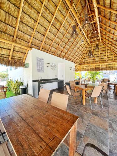 a dining room with a wooden table and chairs at Departamento planta baja con alberca a 5 min de playa! in Manzanillo