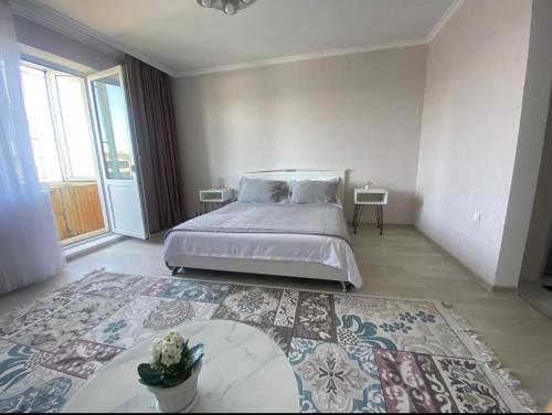1 dormitorio con cama y alfombra grande en Байсеитрум, en Semey