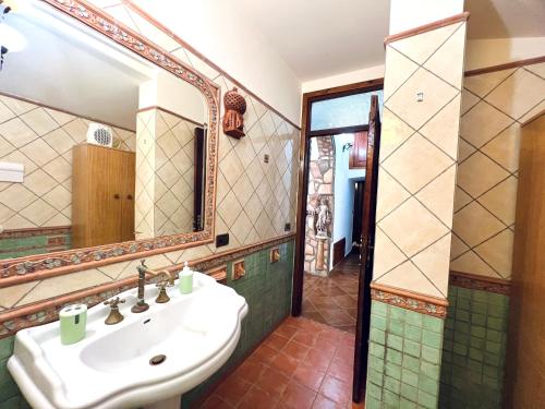 La salle de bains est pourvue d'un lavabo et d'un miroir. dans l'établissement Nonna Sasà, à Torretta