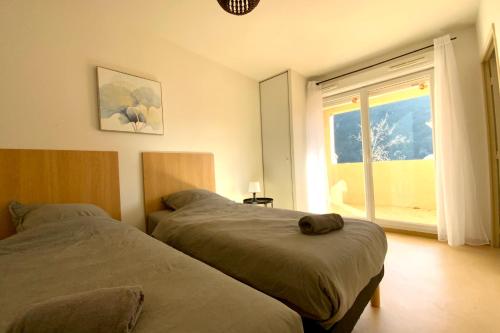 a bedroom with two beds and a large window at Les Naïades C05- 2 bedrooms for 5 people ! in Avène