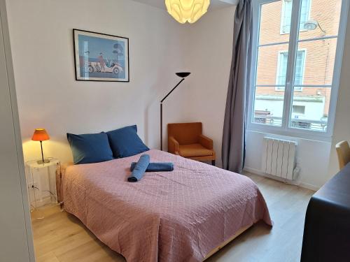 une chambre avec un lit, une chaise et une fenêtre dans l'établissement Orléans hypercentre 4 pers appart avec cachet, à Orléans