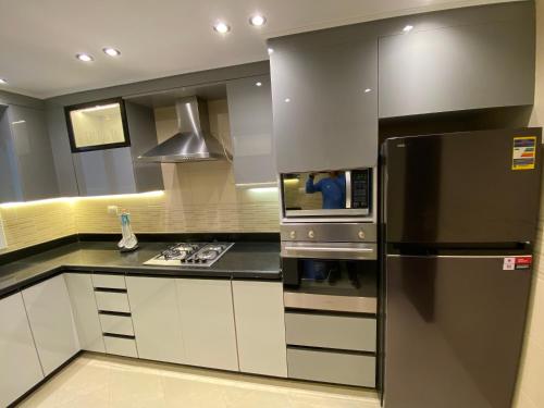 a kitchen with a refrigerator and a stove at Luxurious Family 5BR Pool View Near Airport! in Cairo