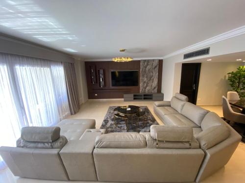 a living room with a couch and a table at Luxurious Family 5BR Pool View Near Airport! in Cairo