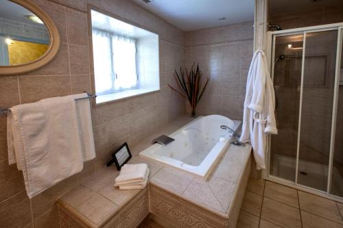 une salle de bain avec baignoire et douche dans l'établissement Ancien moulin rénové proche de Bordeaux, à Carignan