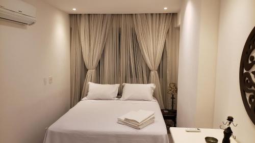 a bedroom with a bed with two books on it at Niterói e um pedacinho do Campo in Niterói