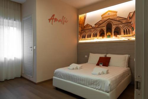 THE SUN HOTEL BOUTIQUE NAPOLI في نابولي: غرفة نوم بسرير مع صورة على الحائط