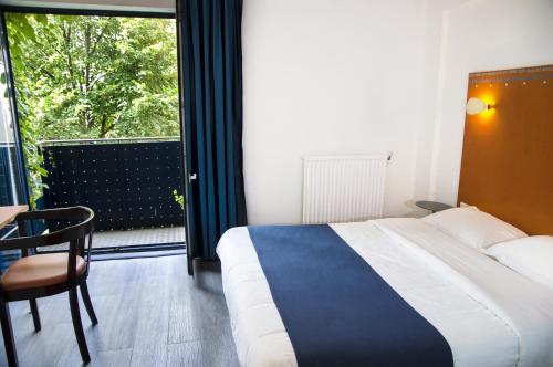
a hotel room with a bed and a chair at Solar Hotel in Paris
