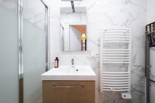 ein Bad mit einem Waschbecken und einem Spiegel in der Unterkunft Studio Cosy Hyper centre - Fibre - Netflix in Segré