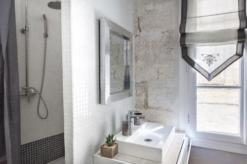 uma casa de banho branca com um lavatório e um chuveiro em Centre Palais des Papes-Balcon B1 Clim - 123avignon em Avignon
