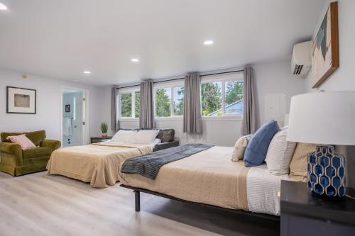a bedroom with two beds and a couch and windows at Burien's Top Unit with Spa-Inspired Bathroom in Burien