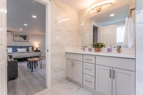 a bathroom with a sink and a room with a bed at Burien's Top Unit with Spa-Inspired Bathroom in Burien