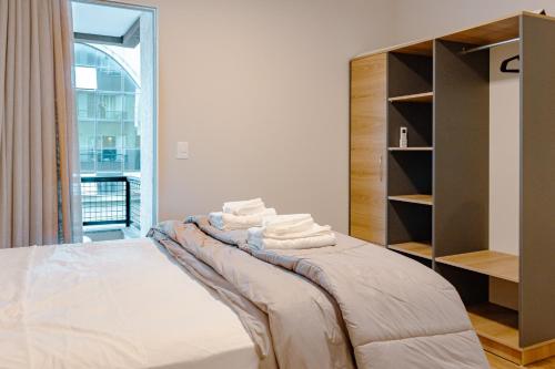 ein Schlafzimmer mit einem Bett mit Handtüchern darauf in der Unterkunft Vista Mar na Rua 303 em Itapema, Garagem e Wifi HU1718 in Itapema