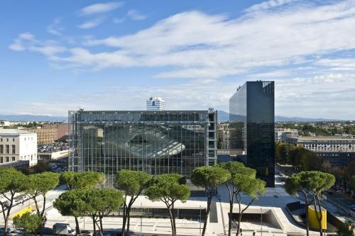 a large glass building with trees in front of it at Mezzo Experience Holiday Home Eur in Rome