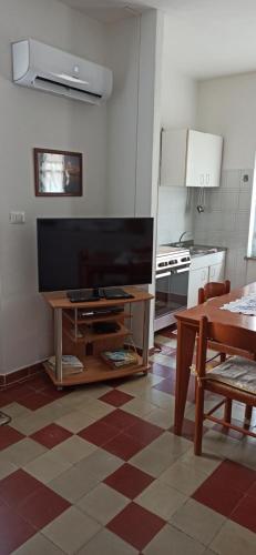 uma cozinha com uma televisão de ecrã plano sobre uma mesa em Borgo Ingurtosu em Ingurtosu