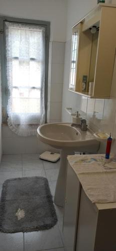 uma casa de banho com um lavatório, uma banheira e um espelho. em Borgo Ingurtosu em Ingurtosu