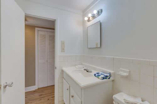 uma casa de banho branca com um lavatório e um espelho em Montgomery Home in Garden District 2 Mi to Dtwn! em Montgomery