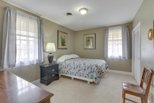 a bedroom with a bed and a table and windows at Garden District Home Near Downtown Montgomery in Montgomery