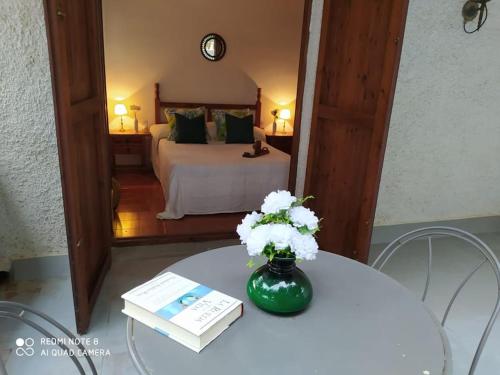 ロダ・デ・バラにあるMasia Del Roc de Sant Caietaのベッド1台、花瓶付きのテーブルが備わる客室です。