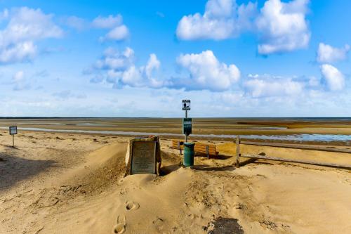 a sandy beach with a sign in the sand at Eastham Glen in Eastham