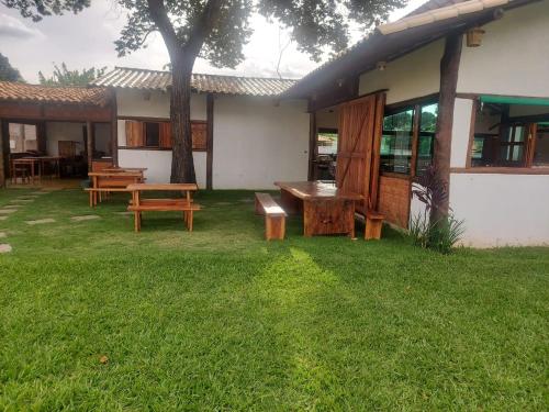 a house with a picnic table and benches in the yard at Pousada Real Cipo in Serra do Cipo