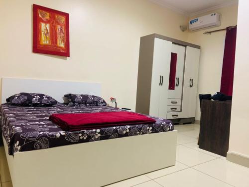 a bedroom with a bed with a red blanket on it at Résidence 44 in Dakar