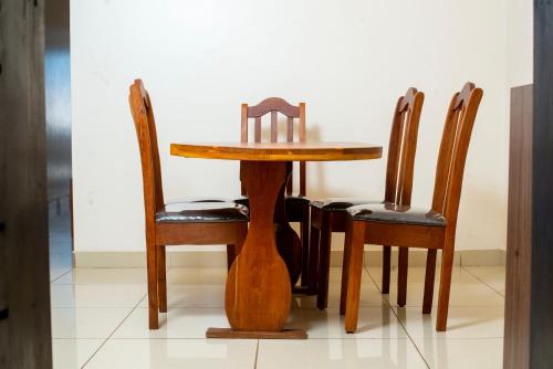 a wooden table with four chairs and a table and a table and chairsearcher at Résidence 44 in Dakar