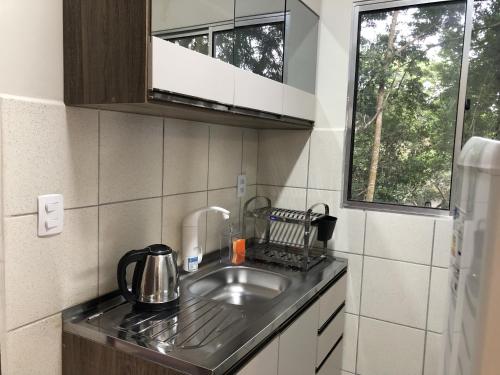 uma pequena cozinha com um lavatório e uma janela em Cabana com Vista para a Lagoa da Conceição RM9376 em Florianópolis