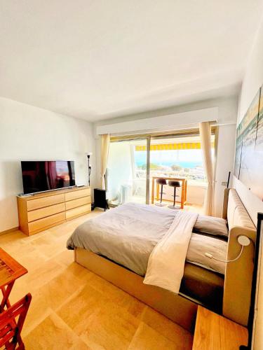 une chambre avec un grand lit et une télévision dans l'établissement #41 MARINA RIVIERA BAY - Marine Baie des Anges - Studio vue Mer et Port, à Villeneuve-Loubet