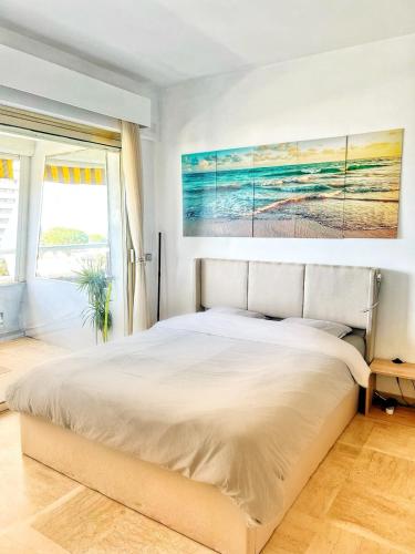 une chambre avec un grand lit et un tableau au mur dans l'établissement #41 MARINA RIVIERA BAY - Marine Baie des Anges - Studio vue Mer et Port, à Villeneuve-Loubet