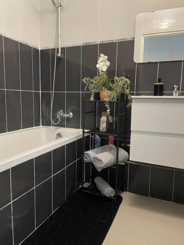 a bathroom with a bath tub and a towel shelf at BY NEPTUNE - Appartement Disneyland Paris in Chessy