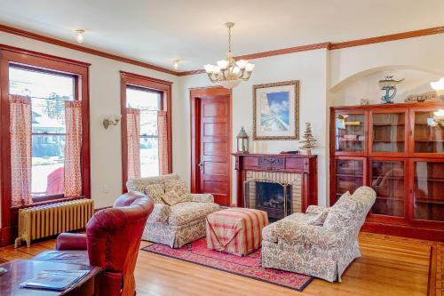 a living room with two chairs and a fireplace at The Blacker House in Manistee