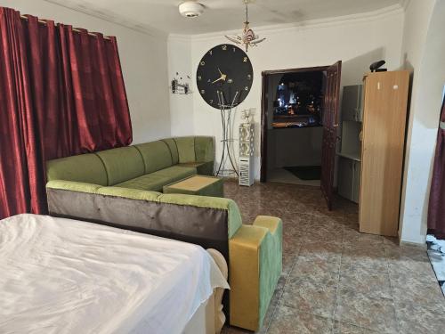een woonkamer met een bank en een klok aan de muur bij apartment B1-9 in Muscat