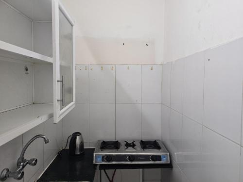 een kleine witte keuken met een fornuis. bij apartment B1-9 in Muscat
