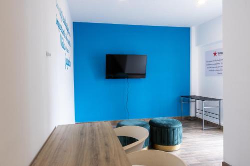 a room with a blue wall and a table and stools at 2min plaza Galerías y 5 min de playa by PartnerHost in Mazatlán