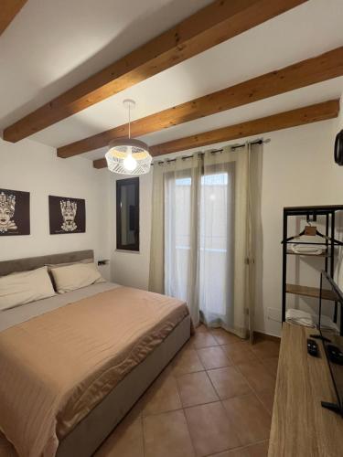 Schlafzimmer mit einem Bett und einem Kronleuchter in der Unterkunft MAESTRALE CASA VACANZA in Isola delle Femmine