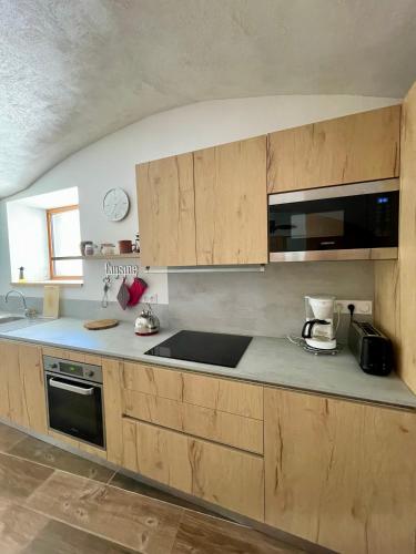 une cuisine avec des armoires en bois et un comptoir dans l'établissement La MaiZon du Bois Rez-de-Chaussée, à Champagny-en-Vanoise