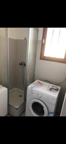 uma casa de banho com uma máquina de lavar roupa e um chuveiro em Studio Saint Cyr sur mer em Saint-Cyr-sur-Mer